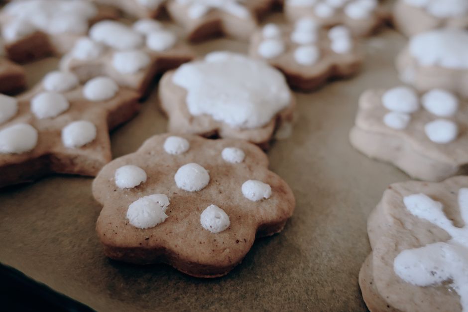 Delicious homemade gingerbread cookies with icing on a baking sheet, perfect for festive occasions.